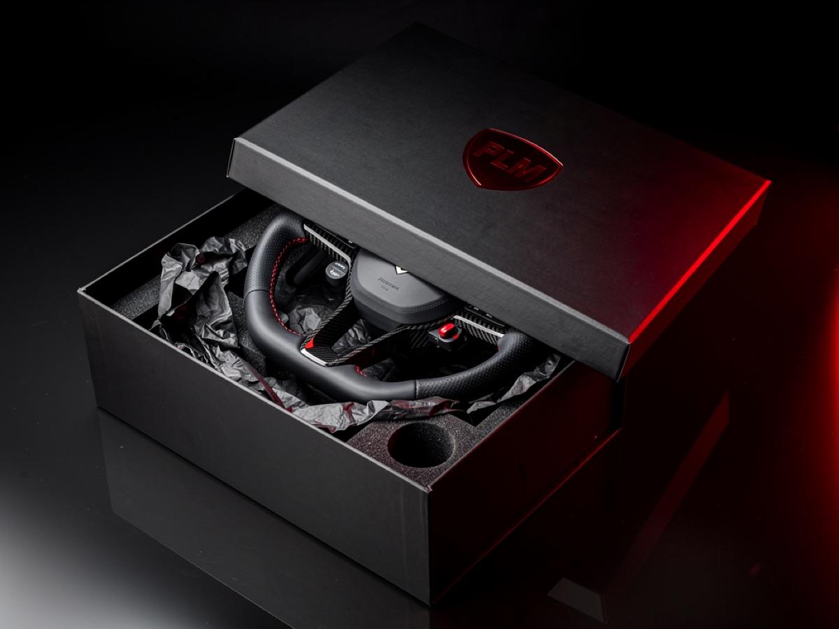 Caja premium PLM abierta con un volante custom envuelto en papel negro